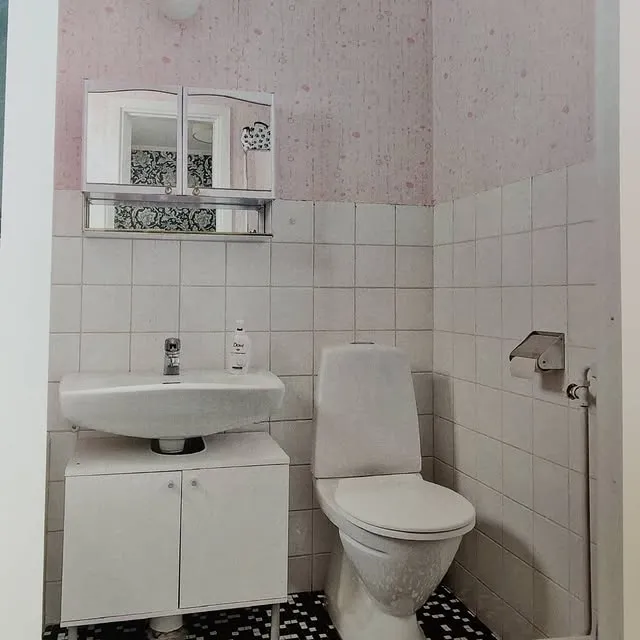 Fristående badkar med grått kakel