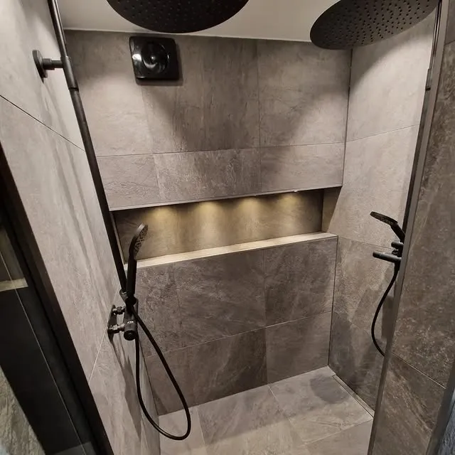 Lyxdusch med mörkt kakel och nischbelysning