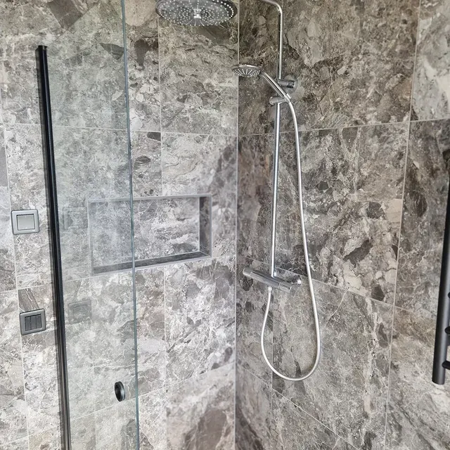 Marmordusch med glasdörr och nisch