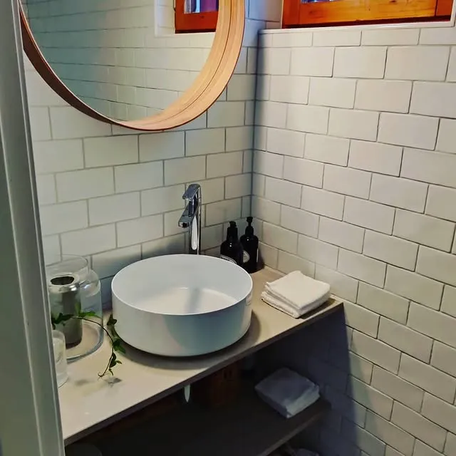 Badrum med subwaykakel och rund träspegel